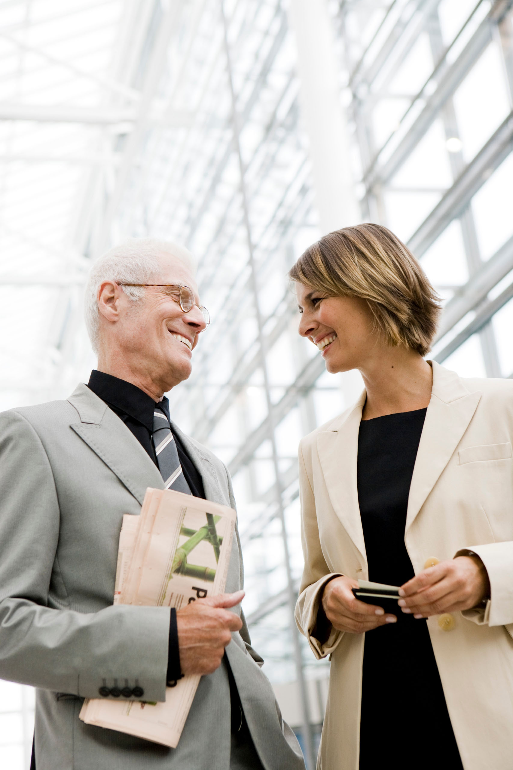 Eine Geschäftsfrau im Gespräch mit ihrem Geschäftspartner, beide lächeln